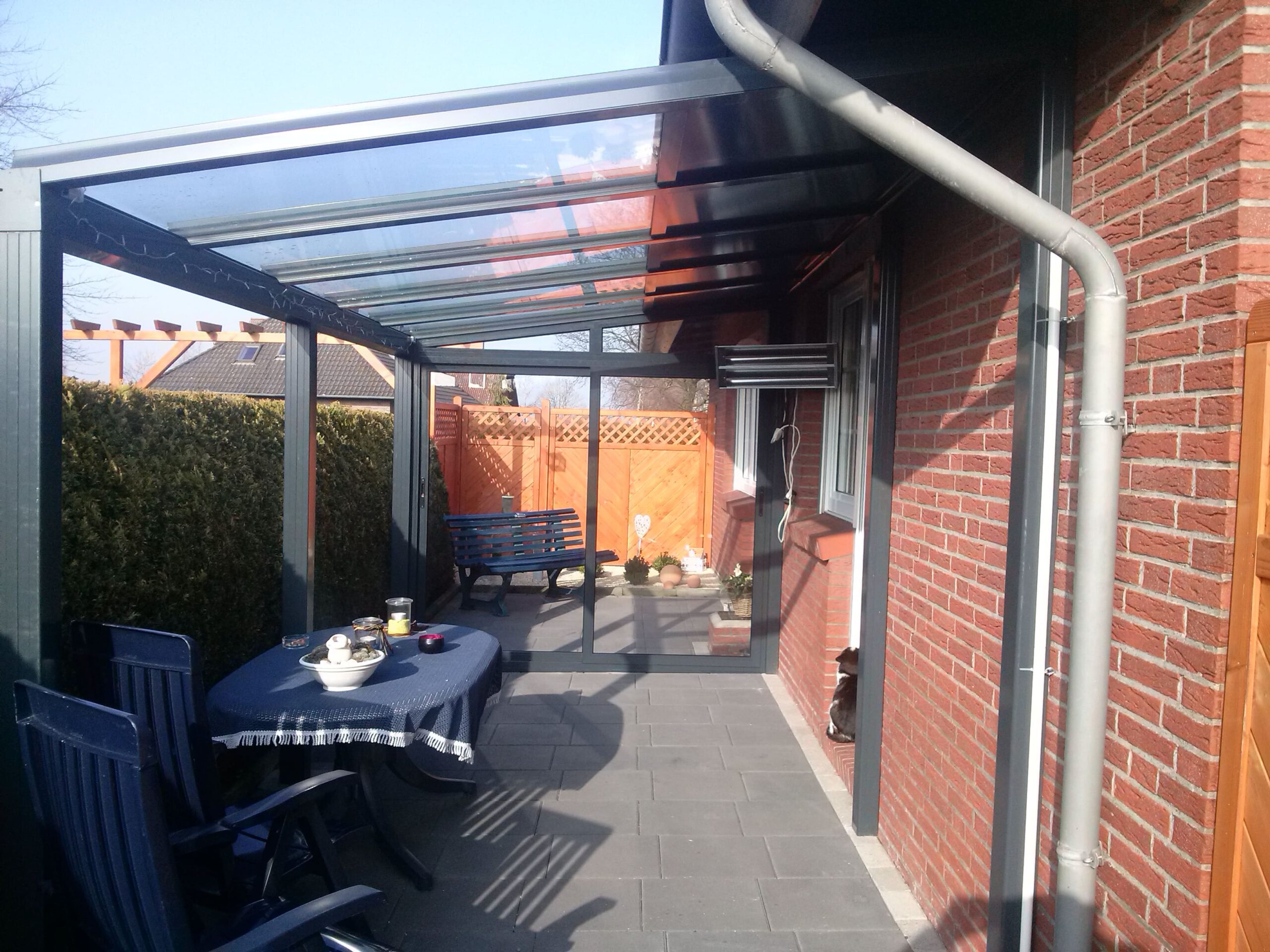 Modernes Terrassendach aus Aluminium und Glas an einem Wohnhaus